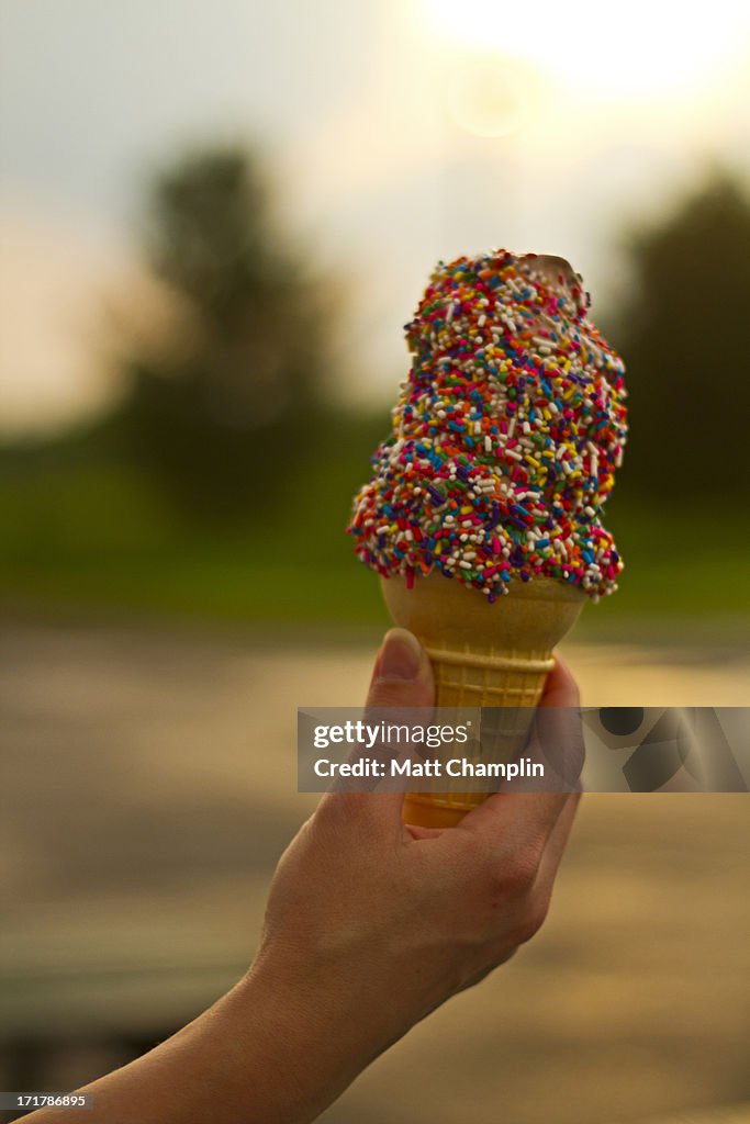 Woman Hand Holding Rainbow Sprinkled Ice Cream