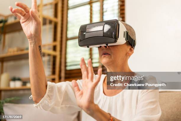 happy senior woman using vr headset to play online video game and connect to social media - real time stock pictures, royalty-free photos & images