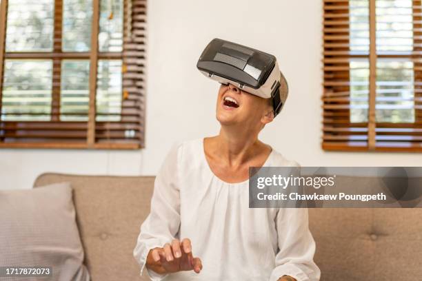 happy senior woman using vr headset to play online video game and connect to social media - real time stock pictures, royalty-free photos & images