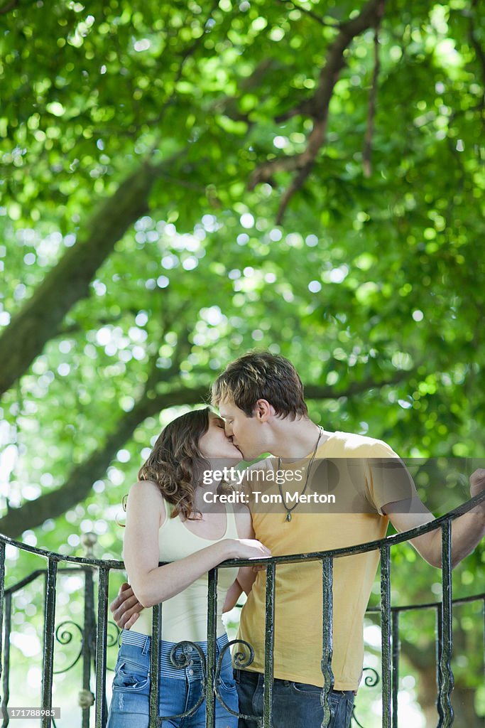 Paar umarmen und küssen nahe dem Geländer im Freien