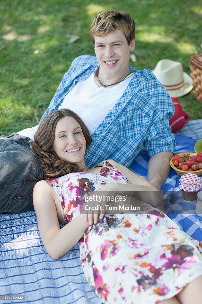 Couple ayant un pique-nique et mettez-vous sur de l'herbe