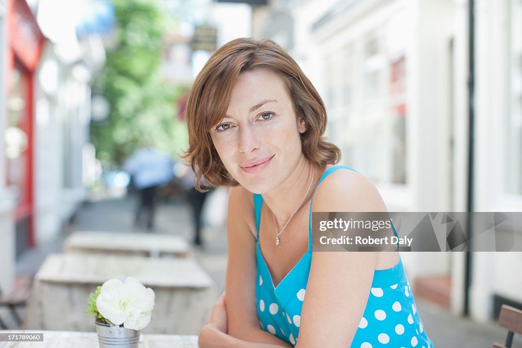 Smiling woman sitting at cafe table
