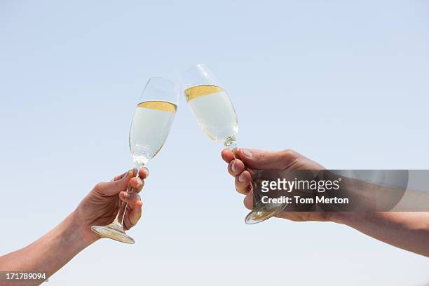 pareja bebiendo champán y brindis - brindis fotografías e imágenes de stock