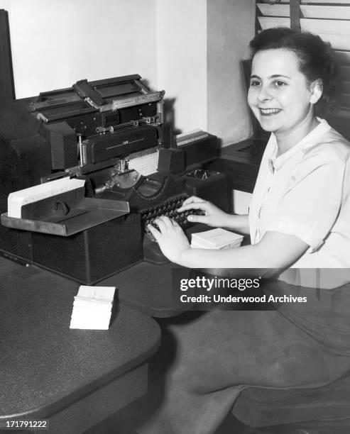 Woman office worker entering data into an IBM punch card machine at the Erie Railroad Company offices, Cleveland, Ohio, February 1951.