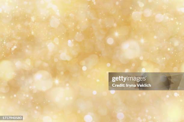 sparkling background with yellow beige bokeh made of elegant gold christmas lights. - resplandeciente fotografías e imágenes de stock