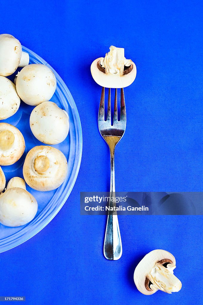 Composition of button mushrooms on blue background