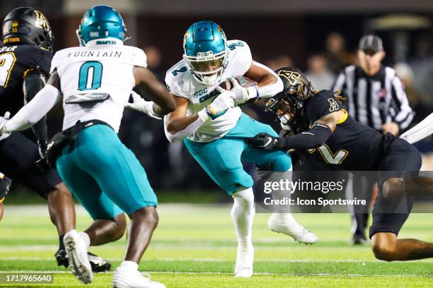 Tyrek Funderburk of the Appalachian State Mountaineers tackles Reese White of the Coastal Carolina Chanticleers during a football game at Kidd Brewer...