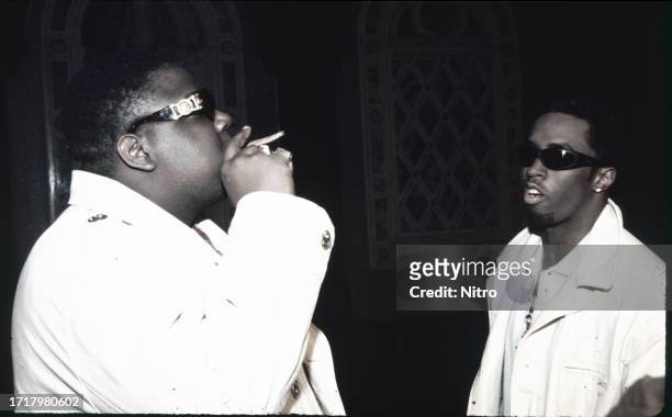 View of American rapper the Notorious BIG and Sean Combs as they talk together on the set of the 'Can't You See' music video , New York, New York,...