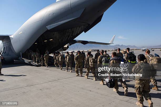 Army soldiers walk to their C-17 cargo plane for departure May 11, 2013 at Bagram Air Base, Afghanistan. U.S. Soldiers and marines are part of the...