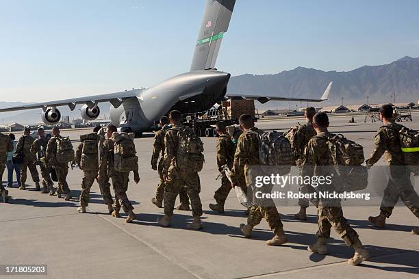 Army soldiers walk to their C-17 cargo plane for departure May 11, 2013 at Bagram Air Base, Afghanistan. U.S. Soldiers and marines are part of the...