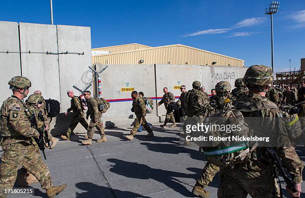 Army soldiers from the 101st Airborne Division, foreground, arrive May 11, 2013 as U.S. Army soldiers depart, background, at Bagram Air Base,...