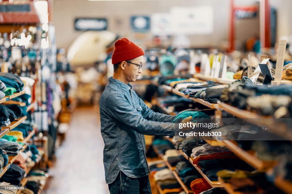 Equipe de varejo adulto dobrando itens em uma loja de roupas