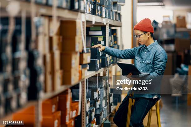 personal de una tienda minorista de hombres adultos de mediana edad que revisan o buscan inventario en una sala de almacenamiento - quiosco fotografías e imágenes de stock