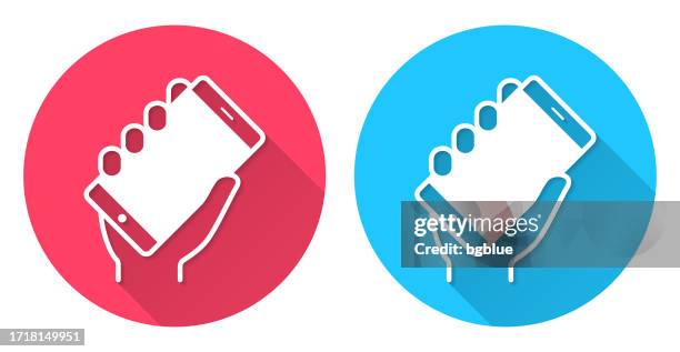 hand holding up smartphone. round icon with long shadow on red or blue background - using tablet blank screen stock illustrations