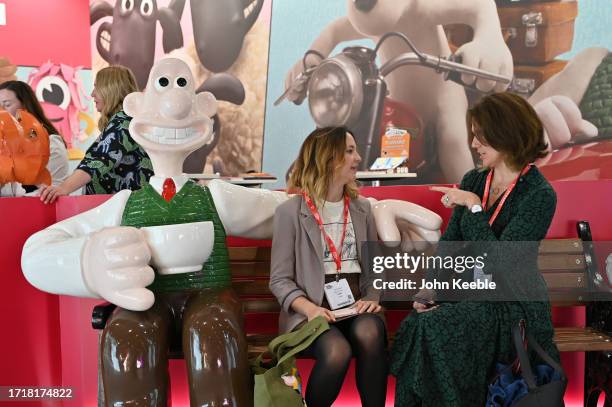 Visitors sit next to a Wallace & Gromit character at the Aardman stand during the Brand Licensing Europe at ExCel on October 04, 2023 in London,...