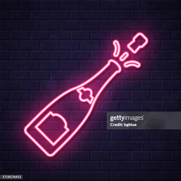 champagne explosion. glowing neon icon on brick wall background - exploding wall stock illustrations