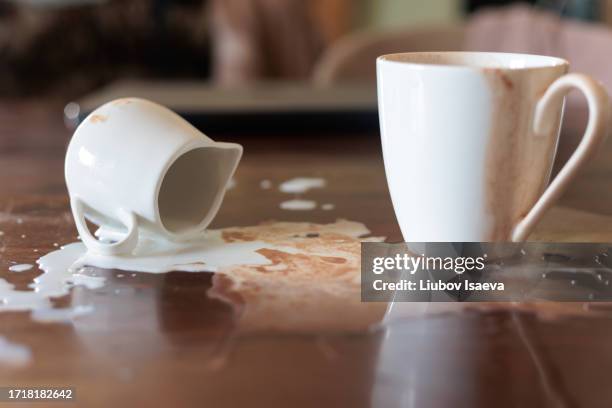 failed breackfast. fallen creamer and milk or cream and coffee spilt on wooden table. - spilt milk foto e immagini stock