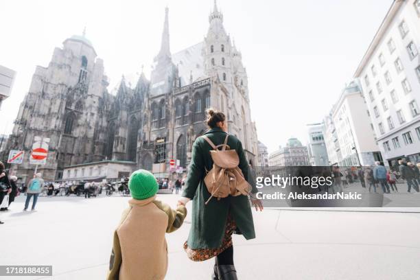 young boy exploring the new city with his mother - austria winter stock pictures, royalty-free photos & images