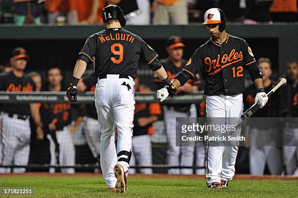 Nate McLouth of the Baltimore Orioles celebrates with teammate Alexi Casilla after hitting a solo home run against the New York Yankees in the...
