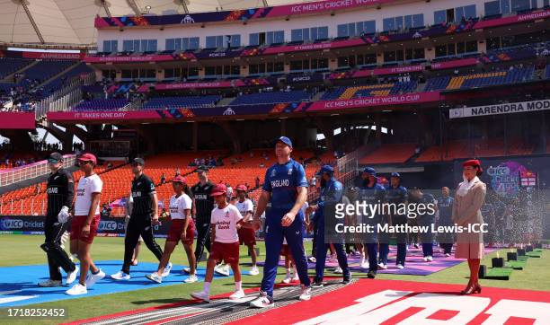 Players of England and New Zealand make their way out for the National Anthems ahead of the ICC Men's Cricket World Cup India 2023 between England...