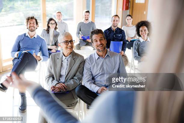 large group of happy business people on presentation in board room. - men and women in a large group listening stock pictures, royalty-free photos & images