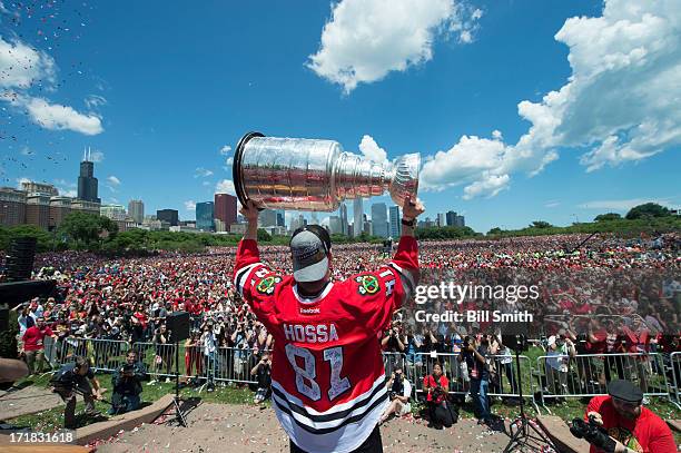 Marian Hossa of the Chicago Blackhawks holds up the Stanley Cup trophy to the crowd in Grant Park during the Blackhawks Victory Parade and Rally on...