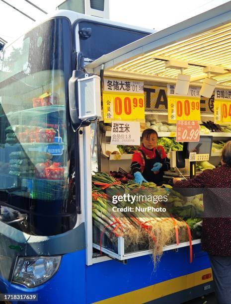 People buy vegetables at a ''bus convenience station'' in Beijing, China, October 11, 2023. Recently, the ''bus convenience station'' converted from...