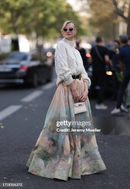 Nadine Leopold is seen outside Zimmermann show wearing pink glasses, heavy knit sweater in white, black Zimmermann belt with golden hardware, long...