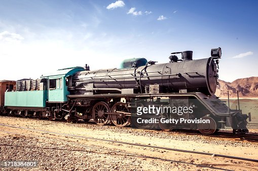 Antique steam locomotive with wagons in the desert of Wadi Rum in Jordan - complete view of the locomotive.