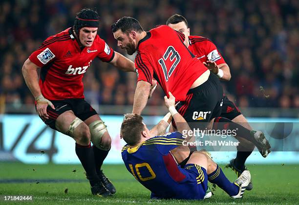 Ryan Crotty of the Crusaders is tackled by Colin Slade of the Highlanders during the round 18 Super Rugby match between the Highlanders and the...