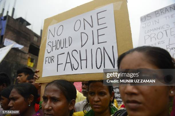 Relatives of Bangladeshi workers who lost their lives in the nine-storey Rana Plaza garment factory building collapse, gather with banners and...