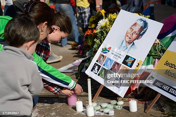 Children light candles for former South African President Nelson Mandela outside the Mediclinic Heart Hospital where Mandela is hospitalized in...