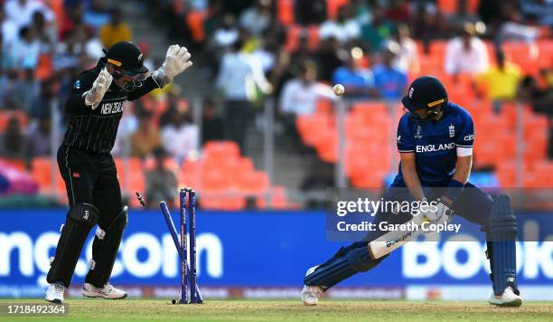 Joe Root of England is bowled by Glenn Phillips of New Zealand as team mate Tom Latham looks on during the ICC Men's Cricket World Cup India 2023...