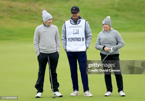 Matthew Fitzpatrick of England and his playing partner his mother Susan Fitzpatrick wait to putt on the sixth hole during the first round of the...