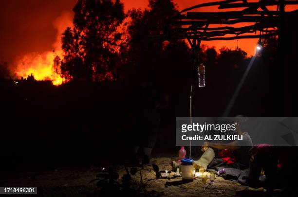 In this photo taken on October 10 a man monitors a forest fire outside of his relative's house as a fire approaches in Ogan Ilir, South Sumatra.