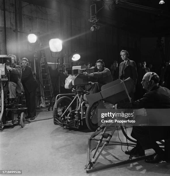 Production staff, floor staff and cameramen operating television cameras to film a performance by the Windmill Theatre dancers in a BBC television...