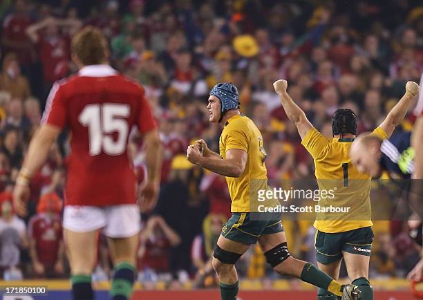 Leigh Halfpenny of the Lions looks on after attempting to kick a penalty as James Horwill and Benn Robinson celebrate victory during game two of the...