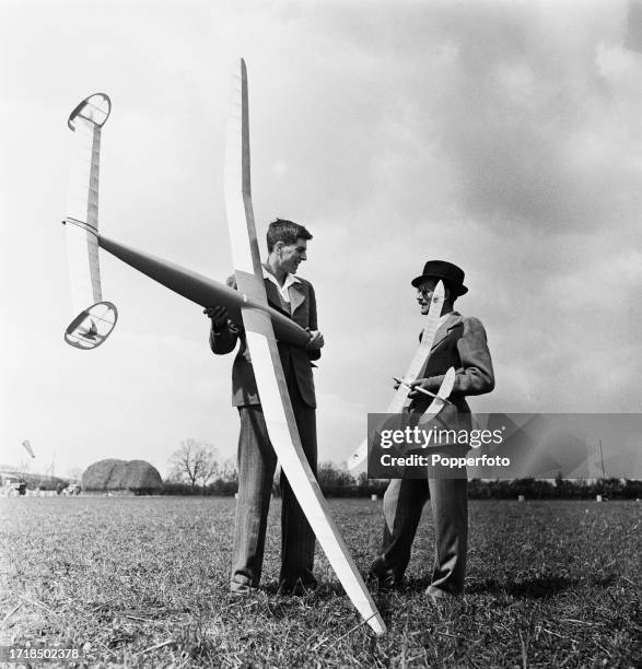 Two proud model plane makers compare their model gliders in a field during a model plane makers' club meeting in England in April 1946.