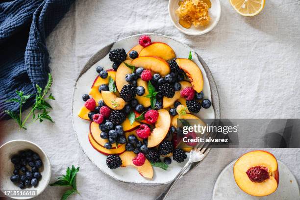 top view of healthy fruit salad breakfast served on table - fruitschaal stockfoto's en -beelden