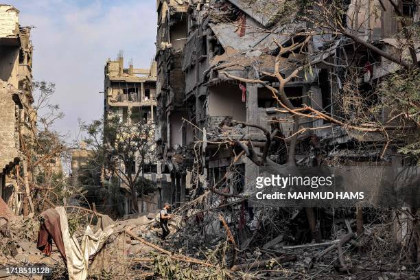 Palestinian walks through destruction in Gaza City's al-Karama neighbourhood on October 11 as raging battles between Israel and the Hamas movement...