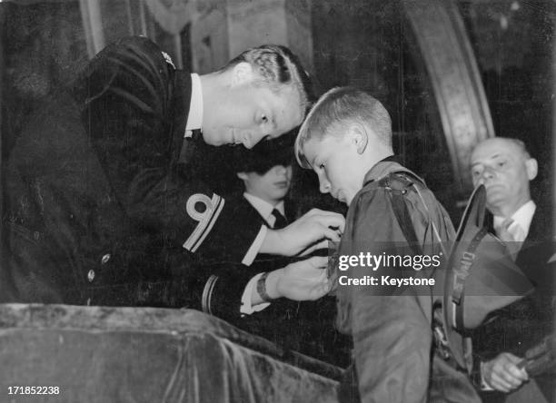 Prince Albert of Belgium, later King Albert II of Belgium awards 10 year old Jean-Claude Genot a prize for bravery at the Academy Palace after he...