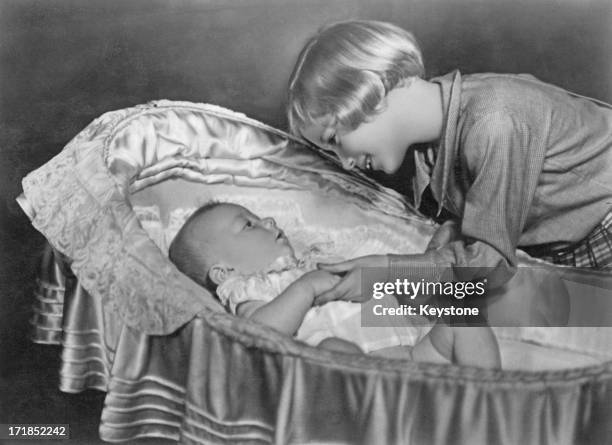 Princess Josephine-Charlotte of Belgium plays with her baby brother Prince Albert of Belgium, later King Albert II of Belgium, 1935.