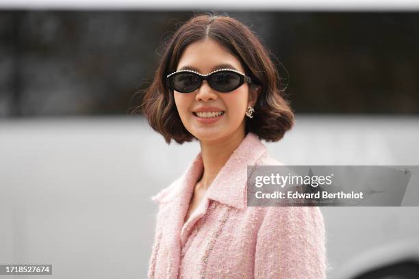 Guest wears sunglasses, Chanel earrings, a pink tweed jacket, outside Chanel, during the Womenswear Spring/Summer 2024 as part of Paris Fashion Week...
