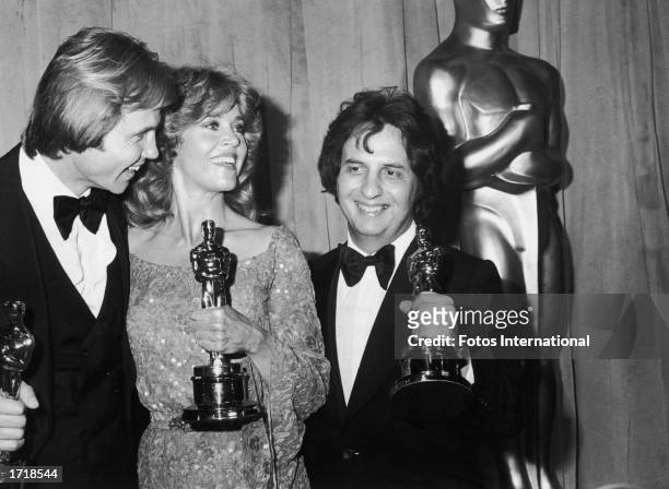 American actors Jon Voight and Jane Fonda pose with American director Michael Cimino, holding their Oscars on stage at the 51st Annual Academy...