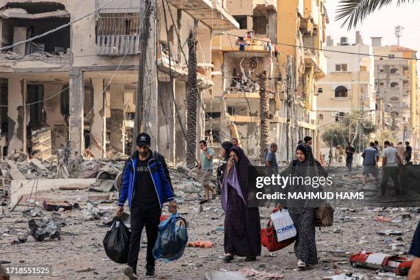 Palestinians leave al-Karama neighbourhood in Gaza City to safer areas on October 11 as raging battles between Israel and the Hamas movement...