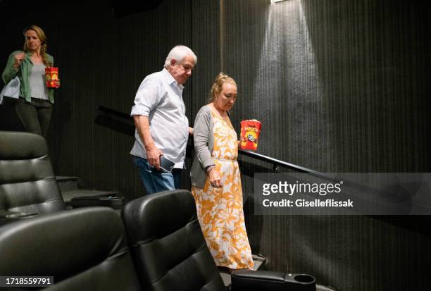 senior couple arriving in cinema hall to watch a movie - couple entering the theater stock pictures, royalty-free photos & images