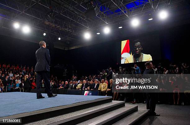 President Barack Obama takes a question from Uganda via teleconference during a town hall style meeting at the University of Johannesburg Soweto in...