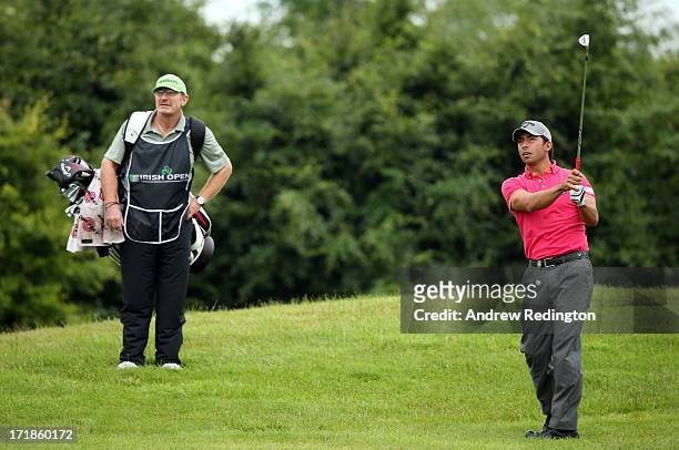 Pablo Larrazabal of Spain hits his second shot on the ninth hole as his caddie John Curtis looks on during the third round of the Irish Open at...