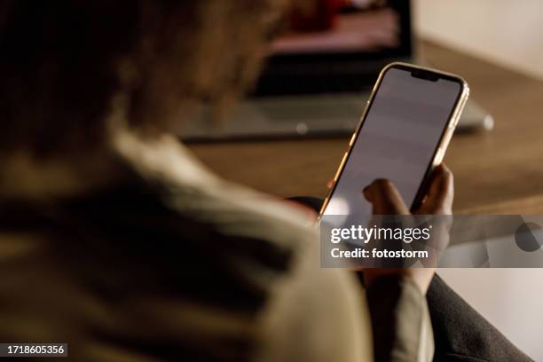 mujer joven desplazándose en su teléfono durante una relajante pausa para el café - vista por la espalda fotografías e imágenes de stock