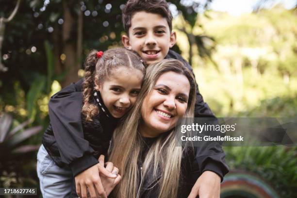 ritratto di madre felice con i suoi bambini nel parco - famiglia con due figli foto e immagini stock